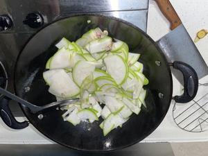 Add the sliced zucchini and stir-fry for one minute, then add a small amount of water