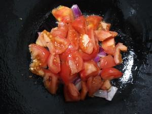 Add the tomatoes and spicy pepper to the pan. Stir-fry until the tomatoes release their juice. Then, add soy sauce, salt, and a pinch of sugar for flavor enhancement.