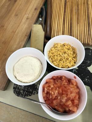 Beat the eggs and mix with an appropriate amount of salt and minced ginger. Cook until finely scrambled, and dice the peeled tomatoes into small cubes.