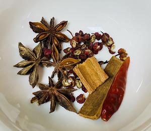 Gather spices: cinnamon, star anise, Sichuan pepper, and dried red chili.