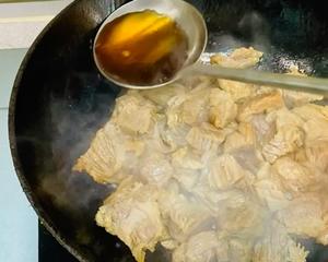 Once the caramelized sugar is evenly mixed, add about 20 grams of yellow wine or cooking wine and continue stir-frying until most of the liquid has evaporated.