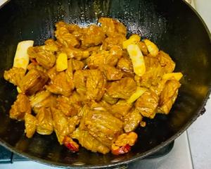 Add the chopped scallions and ginger, mixing well before adding half of the prepared tomato pieces into the pot and stir evenly.