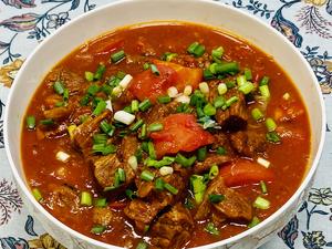 Taste to check if the beef is tender; if so, serve with a sprinkle of chopped green onions on top to finish.