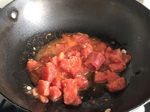 Heat oil in a pan, sauté the chopped green onions, and add the tomatoes to release their juices.