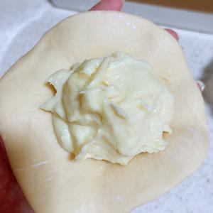 Take one rested dough piece, roll it out, and place a generous spoonful of the cheese durian filling on top.