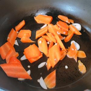 With just a little oil, sauté garlic and then add the carrots, stir-frying until they change color.