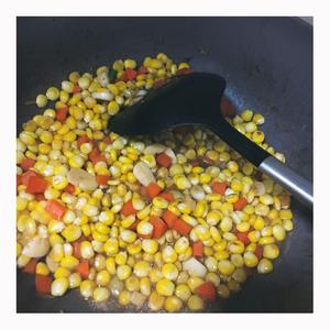 In the same pan, add a small amount of oil, sauté garlic, add corn and carrots, add a bit of water and cover for 2 minutes to cook the corn thoroughly, then season with salt and soy sauce.