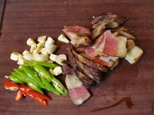 Slice the preserved meat, dice the garlic, and cut the chili peppers into diagonal strips.