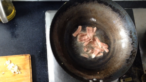 Without cleaning the pan, add some oil and start frying the pork.