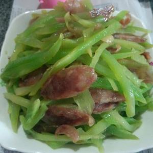 In a hot pan, add garlic slices, then stir-fry the lettuce and sausage until cooked and seasoned, then serve.